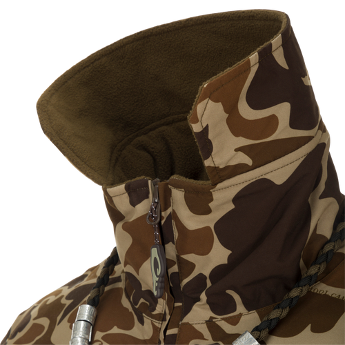 MST Waterproof Fleece-Lined Quarter Zip Jacket close-up showing camouflage pattern, high fleece-lined collar, partially unzipped zipper, braided drawcord, and metal cord locks.