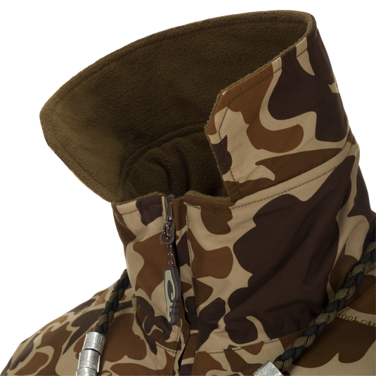 MST Waterproof Fleece-Lined Quarter Zip Jacket close-up showing camouflage pattern, high fleece-lined collar, partially unzipped zipper, braided drawcord, and metal cord locks.
