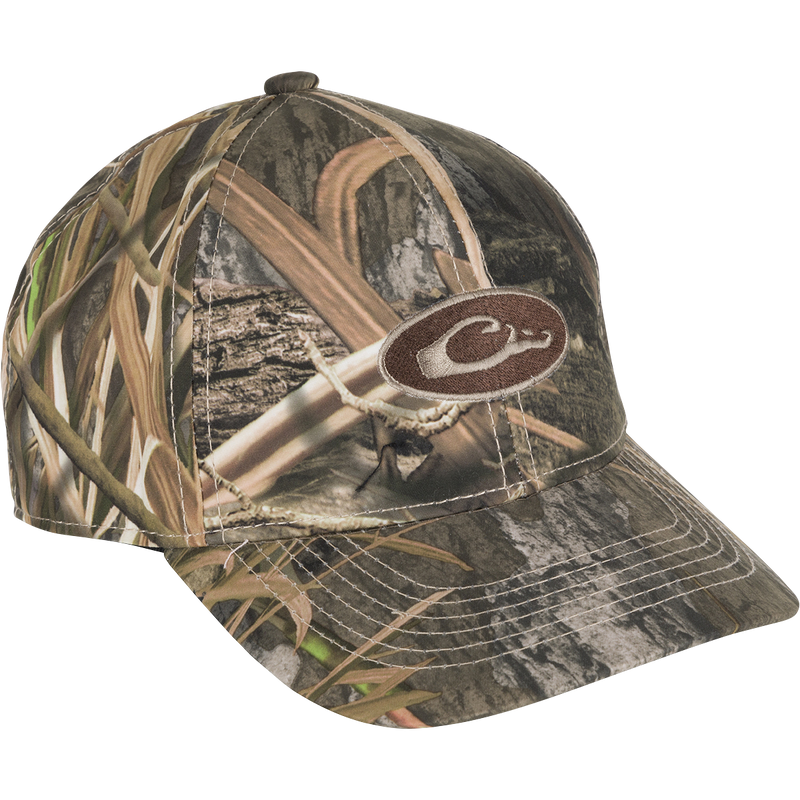 Youth Camo Waterproof Cap with woodland camo pattern, oval C logo patch, and mid-profile six-panel design, offering waterproof, breathable protection for outdoor activities.