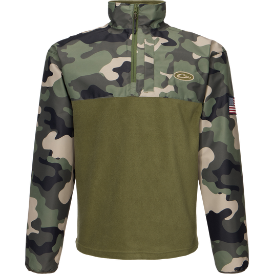 MST Quarter Zip Refuge Eqwader Jacket featuring a close-up of a camouflage pattern, a zipper, and a flag-adorned sleeve, designed for waterfowl hunting comfort and performance.