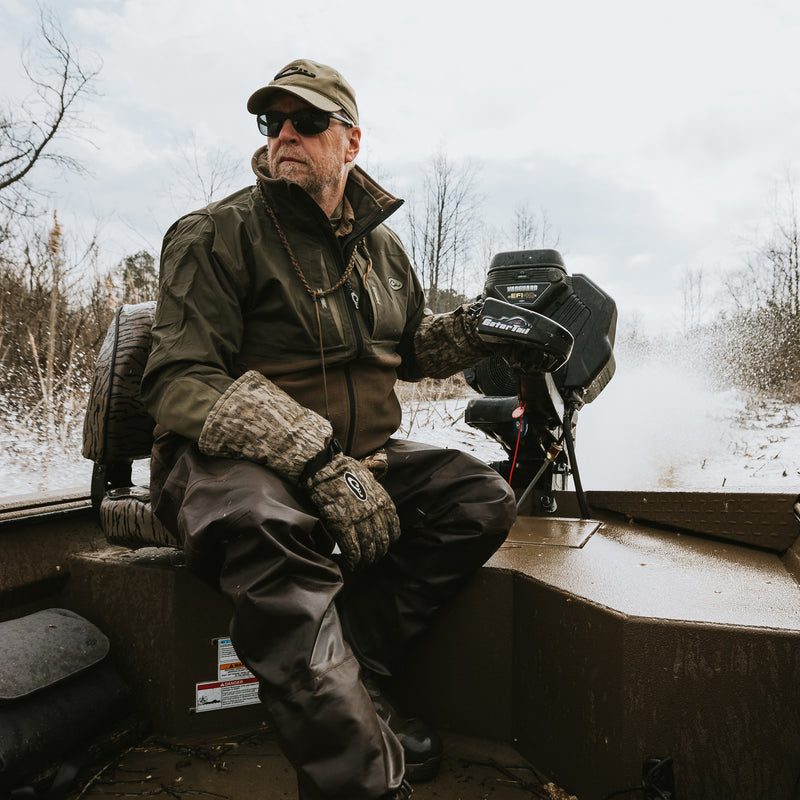 A man in a boat wearing the MST Guardian Eqwader Flex Fleece Full Zip Jacket by Purewhitelaneshop, featuring Guardian Flex™ upper body, 350-gram fleece lower body, and HD3 elbow protection.