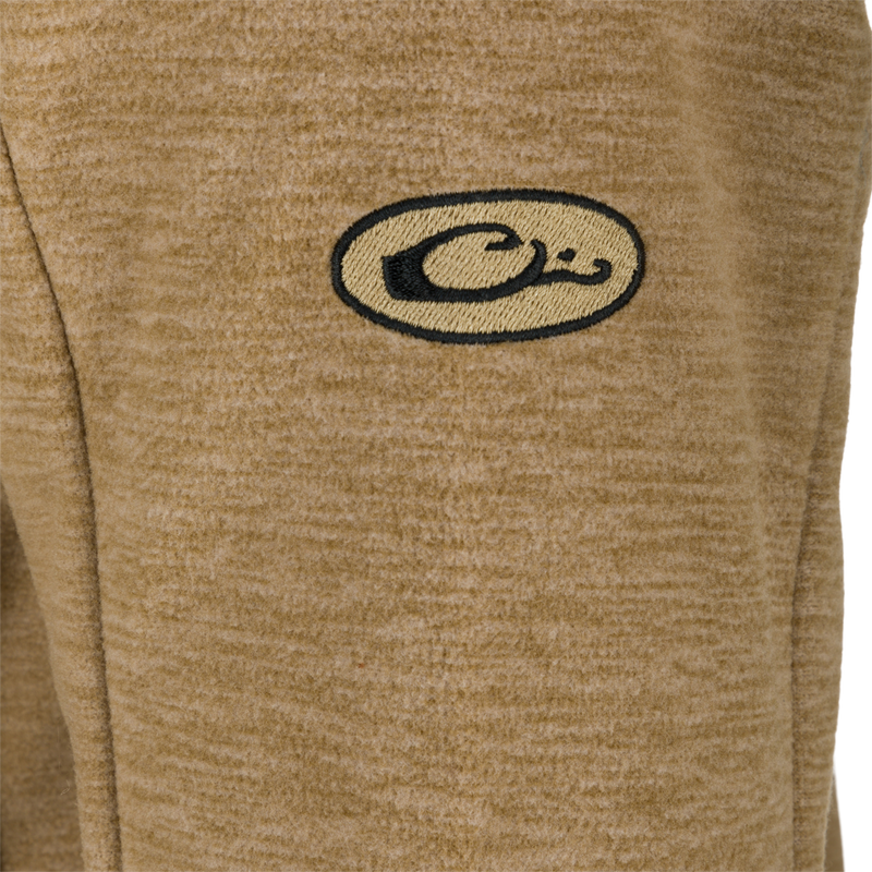 A close-up of the logo on the Heathered Windproof Full Zip jacket by Purewhitelaneshop.