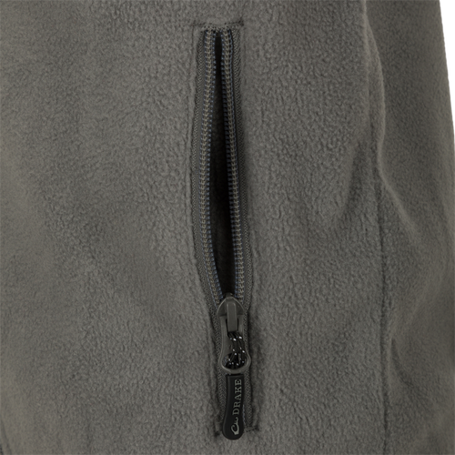 A close-up of the zipper on the Youth Camp Fleece Vest, a durable and comfortable 100% Polyester vest with anti-pill treatment, moisture-wicking properties, and zippered handwarmer pockets.