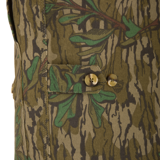 Close-up of the Throwback 80 Field Shirt Jacket, highlighting camouflage fabric and large button detailing, emphasizing its durable construction and functional design features.