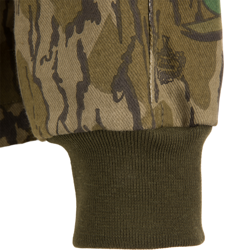 Close-up of the Throwback 80 Field Shirt Jacket showcasing its camouflage pattern, durable stitching, and reinforced elbow design, ideal for rugged outdoor activities.