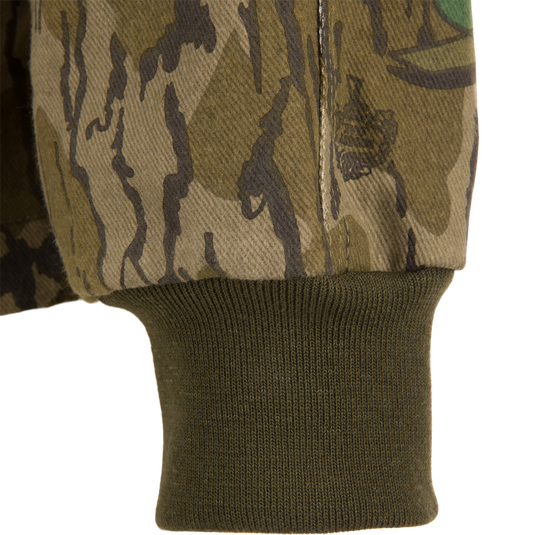 Close-up of the Throwback 80 Field Shirt Jacket showcasing its camouflage pattern, durable stitching, and reinforced elbow design, ideal for rugged outdoor activities.