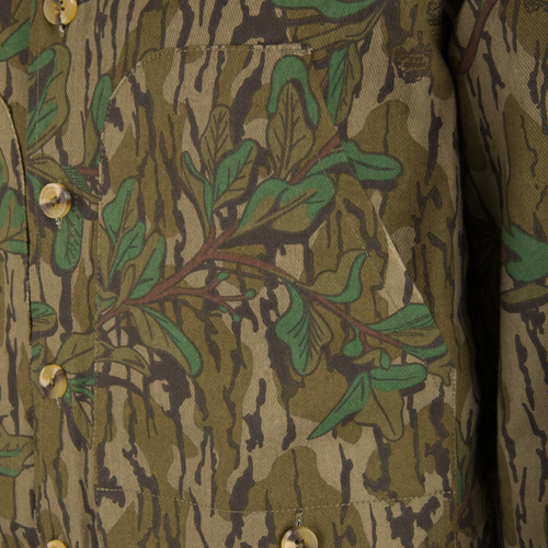 Close-up of the Throwback 80 Field Shirt Jacket, highlighting a durable camouflage fabric, triple-needle stitching, large buttons, and antique brass riveted pockets for added strength.