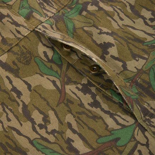 Close-up of Throwback 80 Field Bib showing sturdy cotton twill fabric, camouflage pattern, and antique brass buttons, highlighting durability and vintage style.