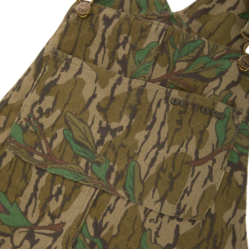 Throwback 80 Field Bib, camouflage overall, showcasing durable cotton twill, antique brass details, and reinforced knees, ideal for hunting and rugged tasks.