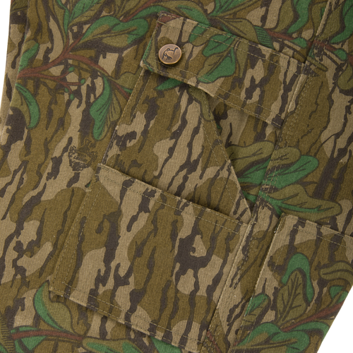 Close-up of the Throwback 80 Field Bib's antique brass button on a pocket, highlighting the durable craftsmanship and vintage style.