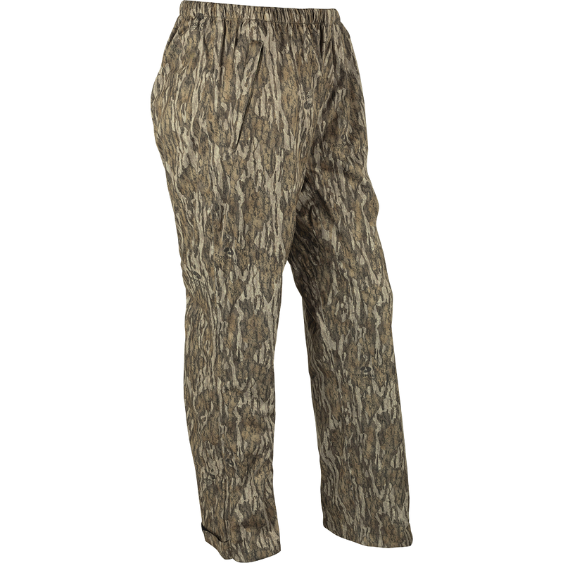 Ultralight Packable Rain Pant, camouflage design, shown in full view, highlighting its waterproof/windproof fabric, ideal for turkey hunting. Comes with a compact elastic closure bag.