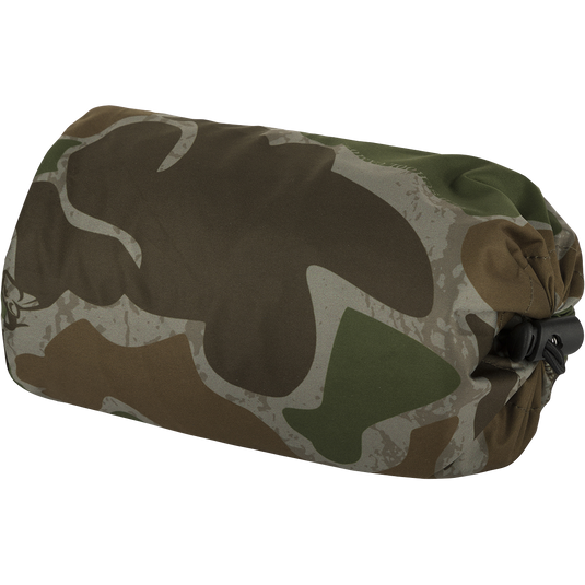 Ultralight Packable Rain Pant - A camouflage bag with a black strap and a close-up of a camouflage fabric. Waterproof and windproof, perfect for spring showers during turkey season. Fits easily in your vest.