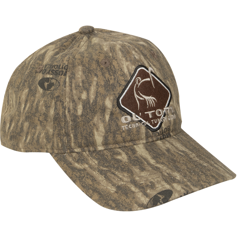 Camo Cotton Ol' Tom Diamond Logo Cap with earth-tone camo, structured six-panel design, and stylized turkey emblem, ideal for hunting. Mid-profile fit, adjustable closure.