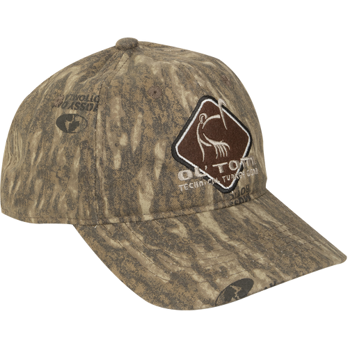 Camo Cotton Ol' Tom Diamond Logo Cap with earth-tone camo, structured six-panel design, and stylized turkey emblem, ideal for hunting. Mid-profile fit, adjustable closure.