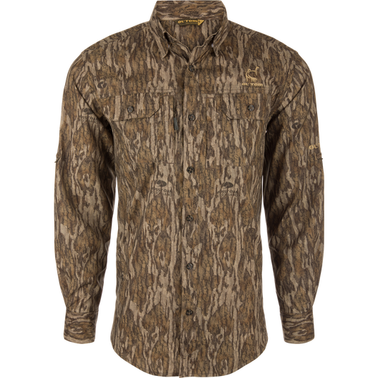 Men's Camo Wingshooter Trey Shirt with tree pattern, long sleeves, hidden button-down collar, vented back, and two chest pockets for hunting.