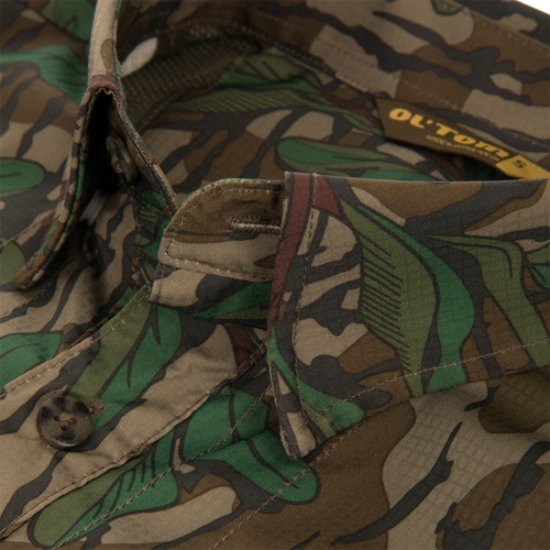 Youth Wingshooter Trey Long Sleeve Shirt close-up showcasing its textured camouflage fabric, button details, and advanced venting features for enhanced performance and comfort.