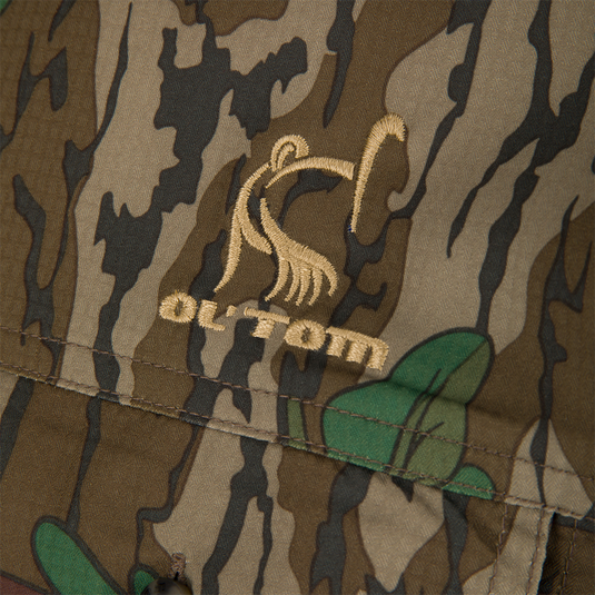 Close-up of camouflage fabric on Youth Wingshooter Trey Long Sleeve Shirt, showcasing textured, moisture-wicking polyester-spandex blend with vented back and functional chest pockets.