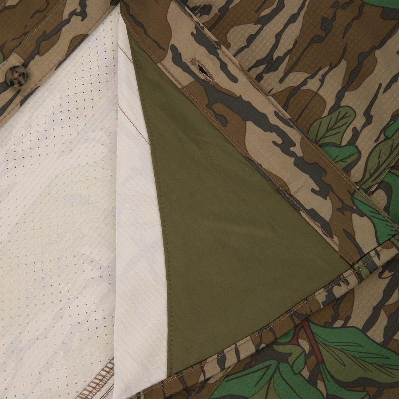 Men's Camo Wingshooter Trey Shirt with camouflage fabric, button-through flap chest pockets, hidden button-down collar, and vented cape back, ideal for hunting enthusiasts.