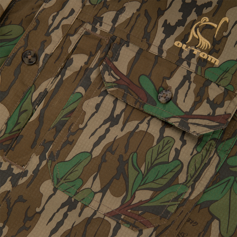 Men's Camo Wingshooter Trey Shirt showcasing close-up of camouflage fabric with buttons, highlighting its technical design features for enhanced performance and comfort.