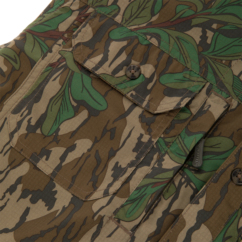 Close-up of Youth Wingshooter Trey Long Sleeve Shirt, featuring a camouflage pattern, button-through flap chest pockets, and vented cape back for enhanced comfort and utility.