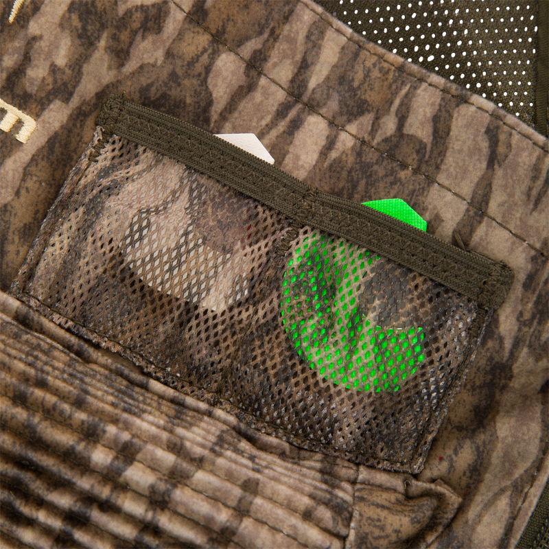 Time & Motion™ Gunslinger Turkey Vest with organized pockets and adjustable straps, designed for efficient gear access, seen in a close-up of a camouflage fabric pocket.