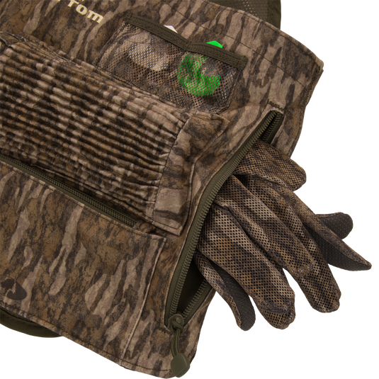 Time & Motion™ Gunslinger Turkey Vest with visible gloves, designed for intuitive gear access, featuring multiple call pockets and a removable seat cushion for hunting convenience.