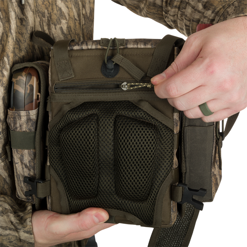 Turkey Chest Pack held by person, showcasing durable design with multiple pockets, removable bino harness, and secure zippered compartments.