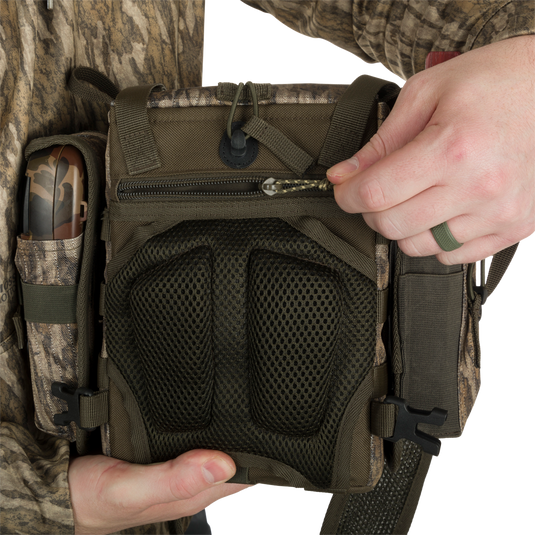Turkey Chest Pack held by person, showcasing durable design with multiple pockets, removable bino harness, and secure zippered compartments.