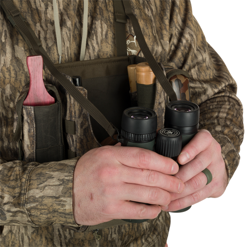 Turkey Chest Pack held by a person, showcasing its bino harness and multiple pockets, ideal for hunting trips with lightweight and durable design.