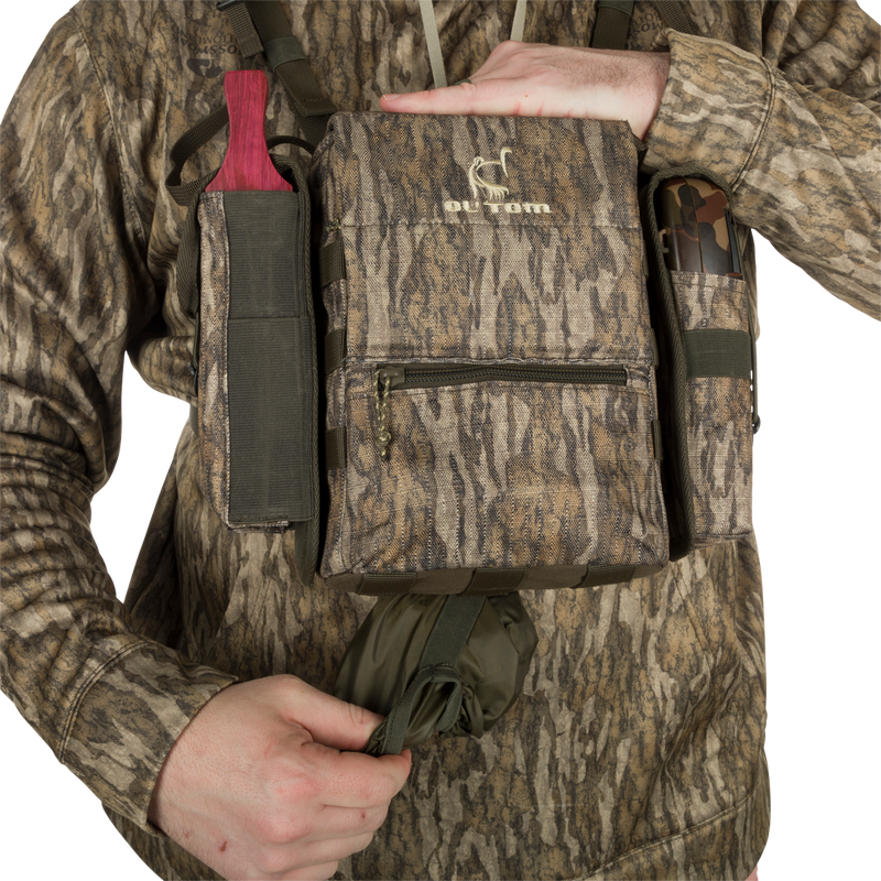 Turkey Chest Pack held by a person, featuring multiple pockets and a detachable bino harness, ideal for hunting trips with lightweight durability.