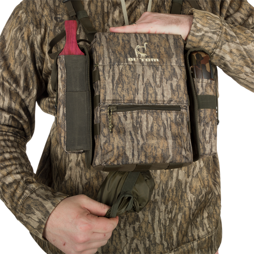 Turkey Chest Pack held by a person, featuring multiple pockets and a detachable bino harness, ideal for hunting trips with lightweight durability.
