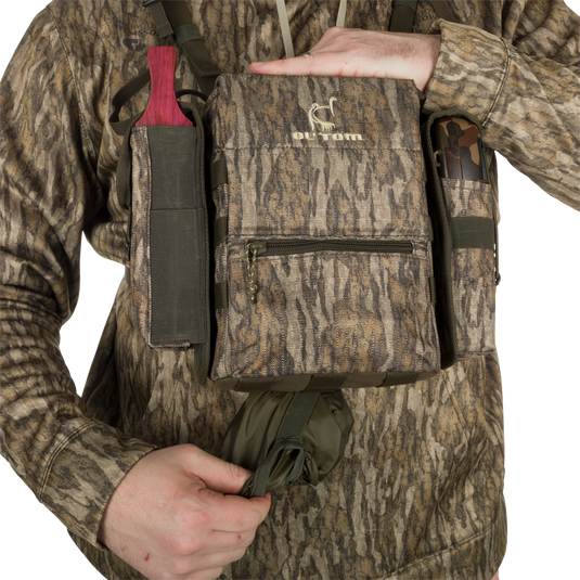 Turkey Chest Pack held by a person, featuring multiple pockets and a detachable bino harness, ideal for hunting trips with lightweight durability.