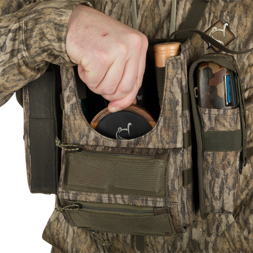 Turkey Chest Pack held by person, showcasing its multiple pockets, straps, and compact design, ideal for hunting trips with a detachable bino harness.