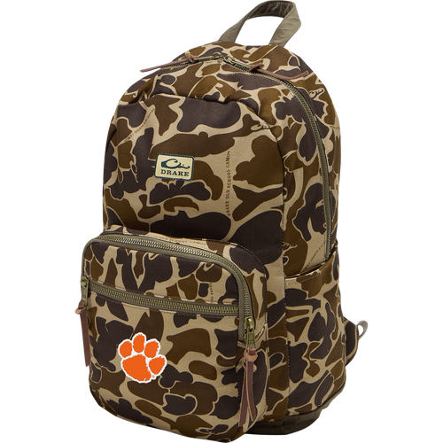 Clemson Throwback 80 Backpack with camo pattern, two front zippered compartments, side pockets, leather pulls, and an orange paw-print logo on durable canvas.
