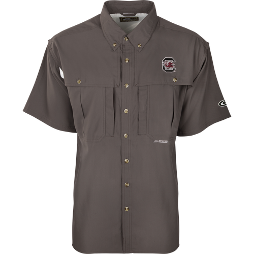 South Carolina S/S Flyweight Wingshooter: A grey shirt with a logo, designed for warm-weather outdoor activities. Features include vented back design, quick-drying fabric, UPF 50+ sun protection, and multiple pockets.