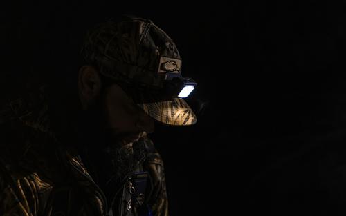 Man in dark area wearing headlamp.