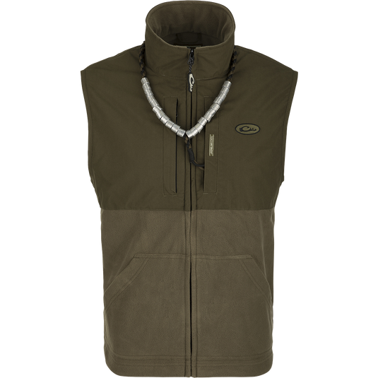 MST Eqwader Vest: A versatile green and grey vest with a silver necklace. Features include waterproof protection, fleece-lined upper body, and multiple pockets for storage. Ideal for hunting and outdoor activities.