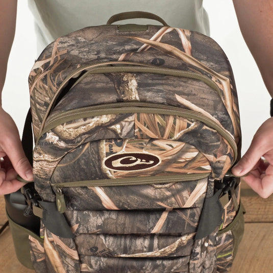 A rugged Camo Daypack by Purewhitelaneshop, ideal for hunting and outdoor adventures. Features include water-resistant material, padded backing, ample storage, hydration pouch, and adjustable straps. Dimensions: 18.5 x 11.5 x 8.5.