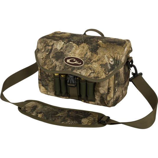 Refuge Blind Bag by Purewhitelaneshop: Camouflage bag with gun case, ammo, and logo. Adjustable strap, durable hardware, outer pocket, shell loops, and waterproof lining. Ideal for daily waterfowl hunting.