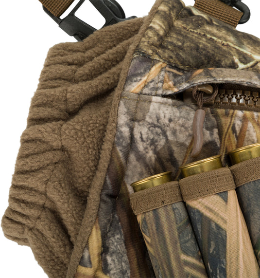 Close-up of the Drake LST Handwarmer Muff, featuring soft fleece lining, front storage pocket, waterproof phone pouch, and clips for wader attachment.