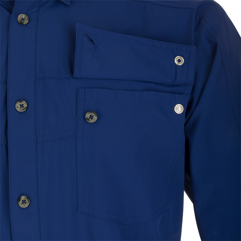 A close-up of the Performance Mesh Paneled Short Sleeve Shirt, featuring a blue fabric with button-through flap chest pockets and a hidden button-down collar. The shirt has laser-punched mesh back panels for increased ventilation and offers UPF 50 sun protection, moisture-wicking, and quick-drying properties. Perfect for outdoor activities.