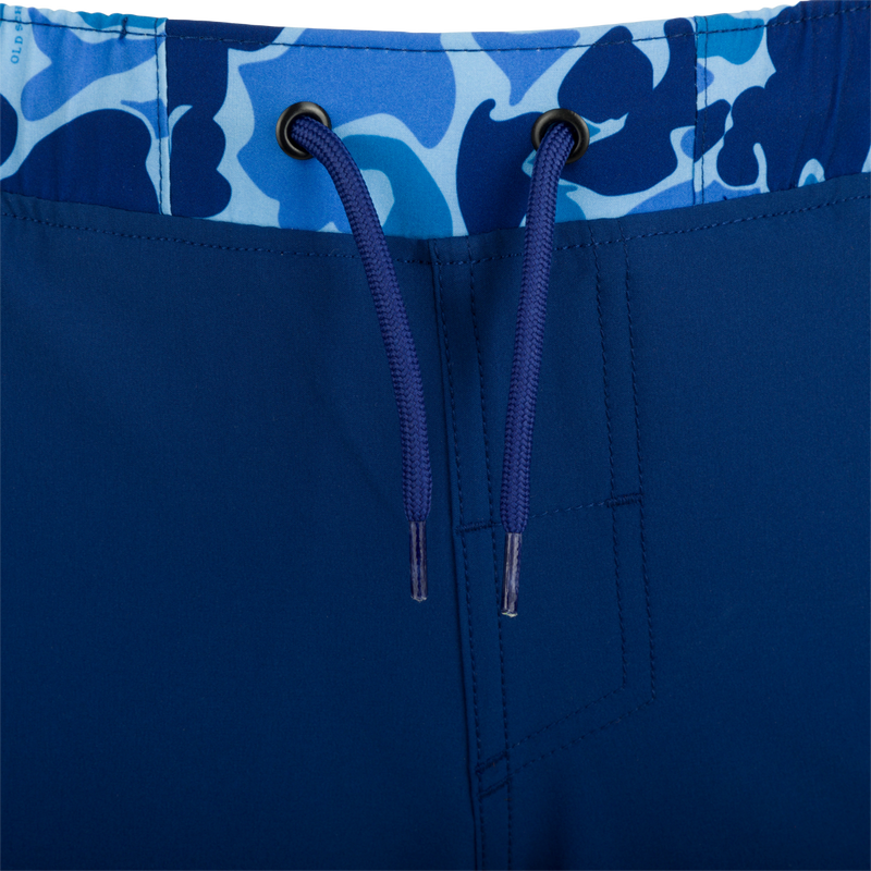 A close-up of the Youth Commando Lined Volley Short 5 with a blue fabric and zipper details.