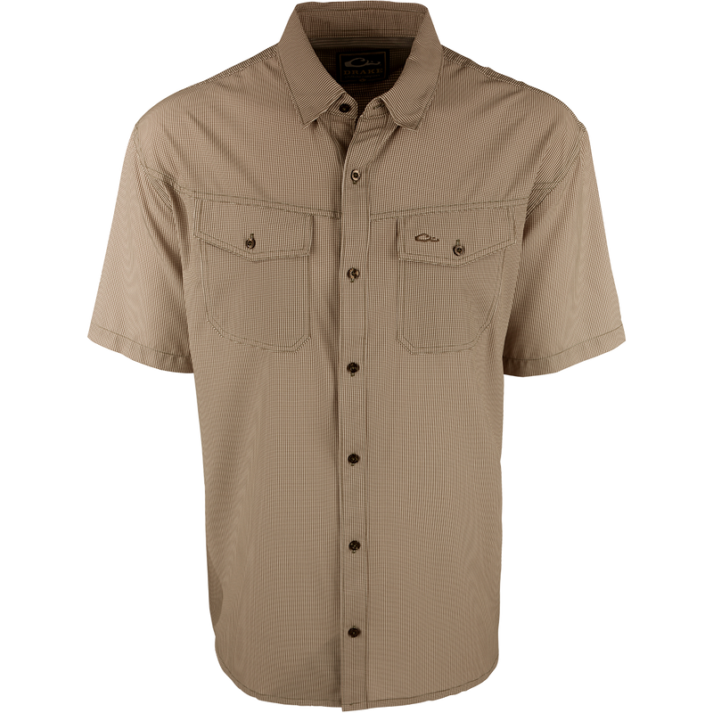A brown checkered shirt with a four-way stretch fabric, moisture-wicking, and two chest pockets with button flaps. Traveler's Check Shirt S/S from Purewhitelaneshop.