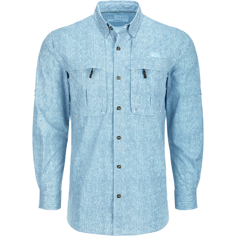 A close-up of the Heritage Heather Shirt L/S, a long-sleeved blue shirt with hidden button-down collar, vented cape back, and two front chest pockets. Lightweight, moisture-wicking, and quick-drying fabric with UPF30 sun protection. Perfect for performance on the water or at the office.