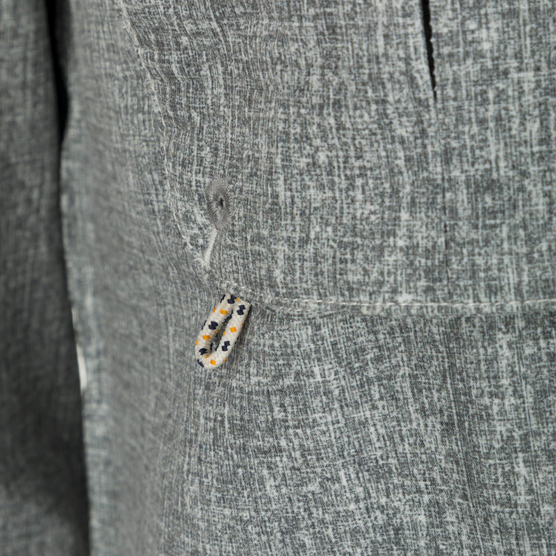 Heritage Heather Shirt L/S - Close-up of jacket button, rope, and grey object. Performance shirt with micro mesh, UPF30, moisture-wicking, and quick-drying fabric. Features hidden button-down collar, vented cape back, chest pockets, and roll-up sleeves. Ideal for hunting, fishing, and outdoor activities.