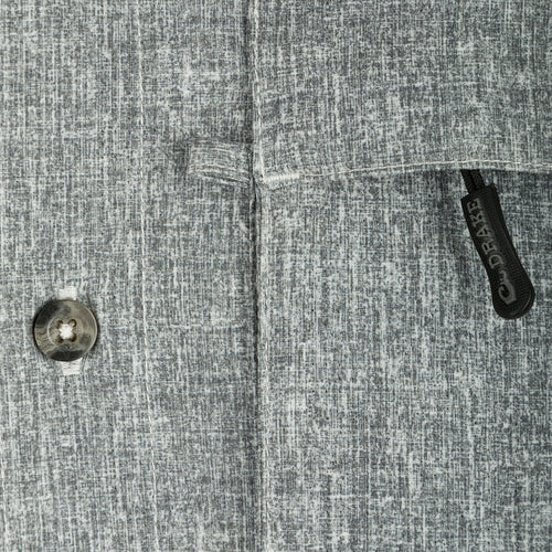 Heritage Heather Shirt L/S: A close-up of a button on a grey patterned shirt made of lightweight, moisture-wicking polyester fabric with UPF30 sun protection.