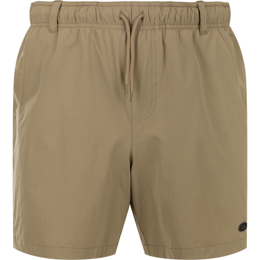 Dock Short 6" - tan swim trunk shorts made of durable nylon/spandex fabric. Features quick-drying, water-resistant finish. Elastic waist with drawstring and belt loops. Mesh-lined pockets and YKK zippered back pockets. Versatile for boat to dock transitions.