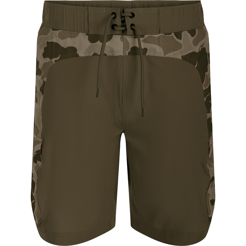 A pair of Commando Lined Board Shorts with camouflage print, cargo pockets, and a 9-inch inseam. Made of 88% polyester and 12% spandex for 4-way stretch. Quick-drying, moisture-wicking, and water-resistant. Features an elastic waistband with a drawstring for a perfect fit. Includes a built-in liner for added comfort. Perfect for beach or bar.