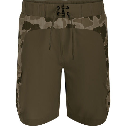 A pair of Commando Lined Board Shorts with camouflage print, cargo pockets, and a 9-inch inseam. Made of 88% polyester and 12% spandex for 4-way stretch. Quick-drying, moisture-wicking, and water-resistant. Features an elastic waistband with a drawstring for a perfect fit. Includes a built-in liner for added comfort. Perfect for beach or bar.