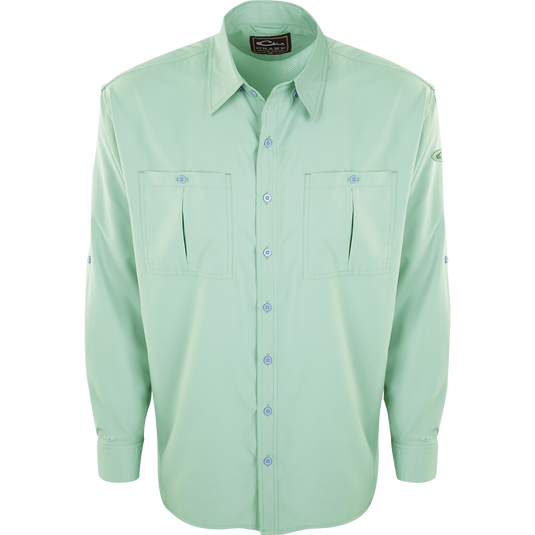 A close-up of the Flyweight Shirt with Vented Back L/S, featuring a green button-up design, collar, and sleeve. Made of ultra-lightweight polyester, it offers quick-drying, moisture-wicking, and breathable properties. With Sol-Shield™ UPF 50+ sun protection, vented mesh back, and horizontal chest pockets, it's perfect for warm-weather outdoor activities.